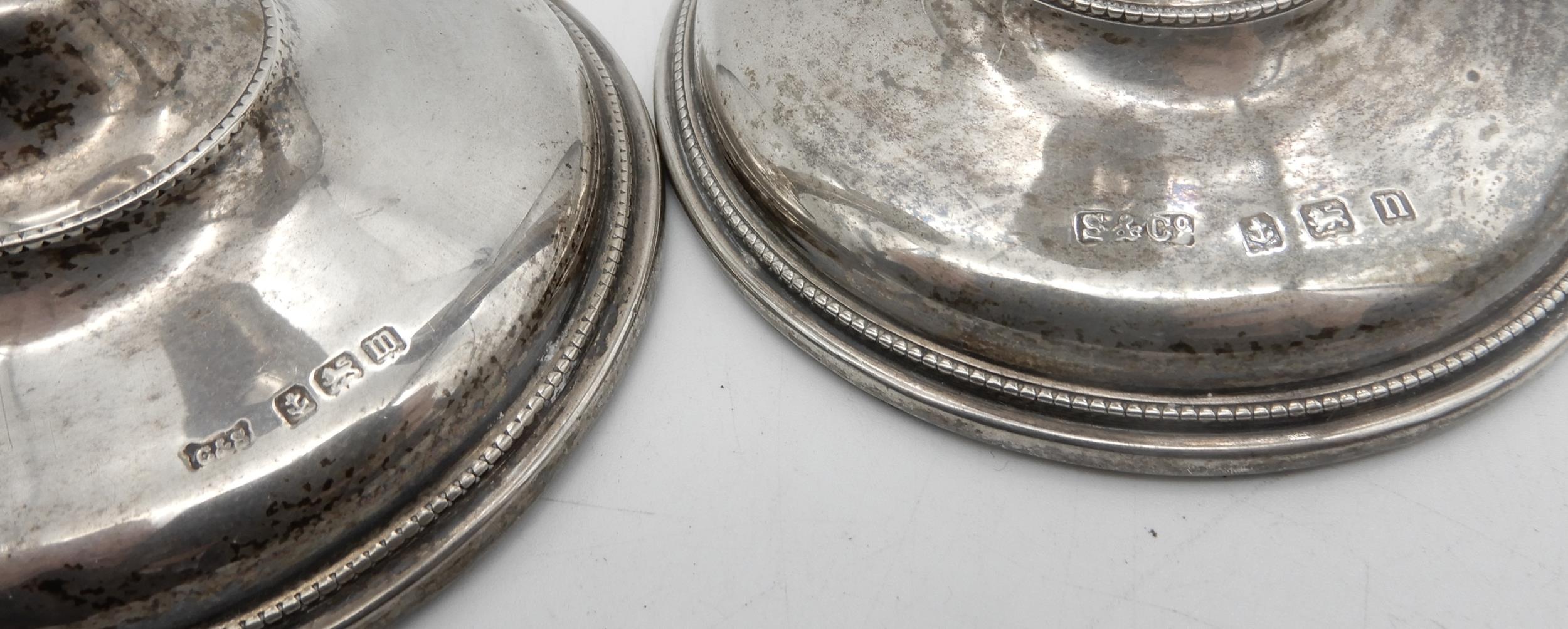 A matched pair of silver candlesticks, of tapering cylindrical form, on a stepped circular base with - Image 2 of 2