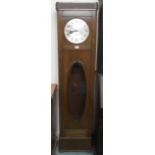 A 20th century oak long cased clock with silvered dial bearing Arabic numerals over glazed door