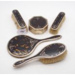 A George V tortoiseshell and silver inlaid dressing table set, comprising two clothes brushes, a