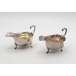 A pair of silver sauce boats, in the Georgian style, with flying scroll handles and shaped rims,