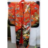 A modern Japanese marriage ceremonial kimono with embroidered decoration on a red and black silk gro