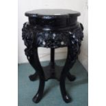A 20th century Oriental ebonised jardinière plant stand with shaped top over carved floral