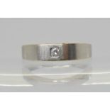 A 9ct white gold band ring set with a 0.07ct diamond, finger size L1/2, weight 2.7gms Condition