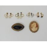 A yellow metal mourning brooch set with a bulls eye agate, with glazed panel to the reverse, a 9ct
