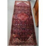 A dark blue ground Persian Soroka runner with red central medallion, floral spandrels and