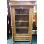 A 20th century pine glazed display cabinet with shaped cornice over single glazed door over single