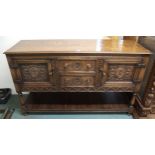 A 20th century oak Jacobean style sideboard with two central drawers flanked by cabinet doors,