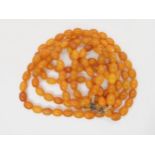 A long string of amber coloured beads, weight 93.8gms Condition Report:Not available for this lot.