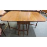 A 20th century oak drop leaf dining table on turned barley twist supports, 74cm high x 51cm (149cm