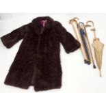A dark brown fur coat and assorted walking sticks and parasols Condition Report:Not available for