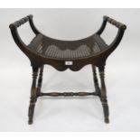 A 20th century mahogany bergere stool with turned arms and stretchered supports, 69cm high x 59cm