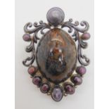 A silver pendant brooch set with star rubies and a large blue and gold tigers eye specimen stone