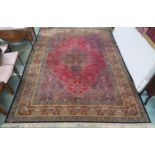 A red ground Tabriz rug with dark blue central medallion, matching spandrels and a yellow floral