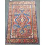 A pink ground Hamadan rug with geometric central medallion, cream floral spandrels and multicoloured