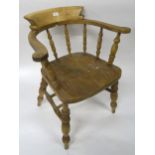 A 20th century elm and beech horseshoe back chair with turned spindle uprights over shaped seat on