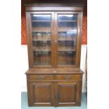A Victorian oak glazed bookcase with moulded cornice over pair of glazed doors over two drawers over