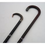 An ebonised walking stick with curved horn handle and narrow band stamped "Silver"; and another