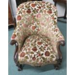 A Victorian mahogany framed parlour armchair with floral tapestry upholstery on carved scrolling