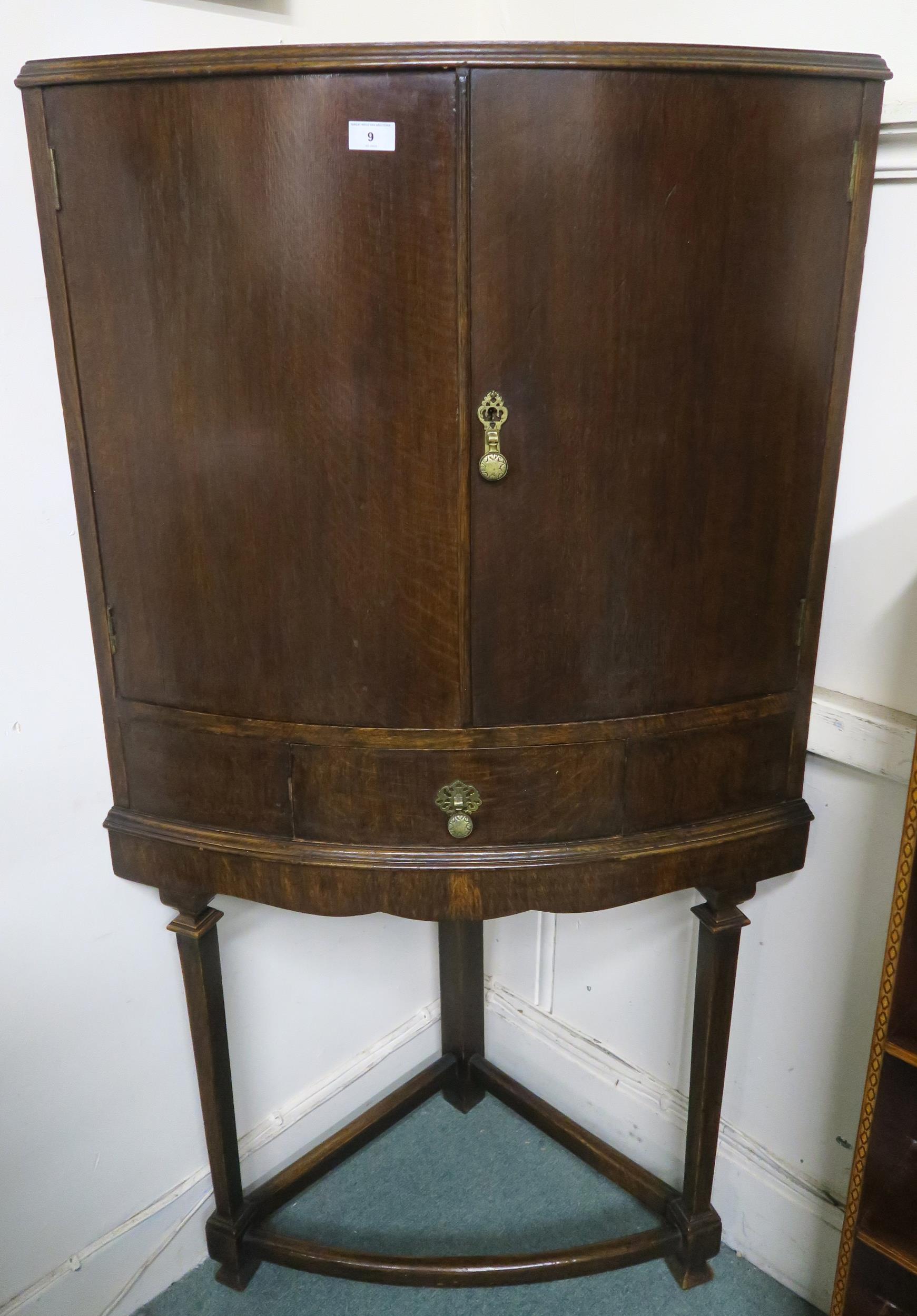 An early 20th century oak bow fronted corner cabinet, 146cm high x 78cm wide x 48cm deep Condition