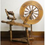 A 20th century pine treadle spinning wheel, 84cm high Condition Report:Available upon request