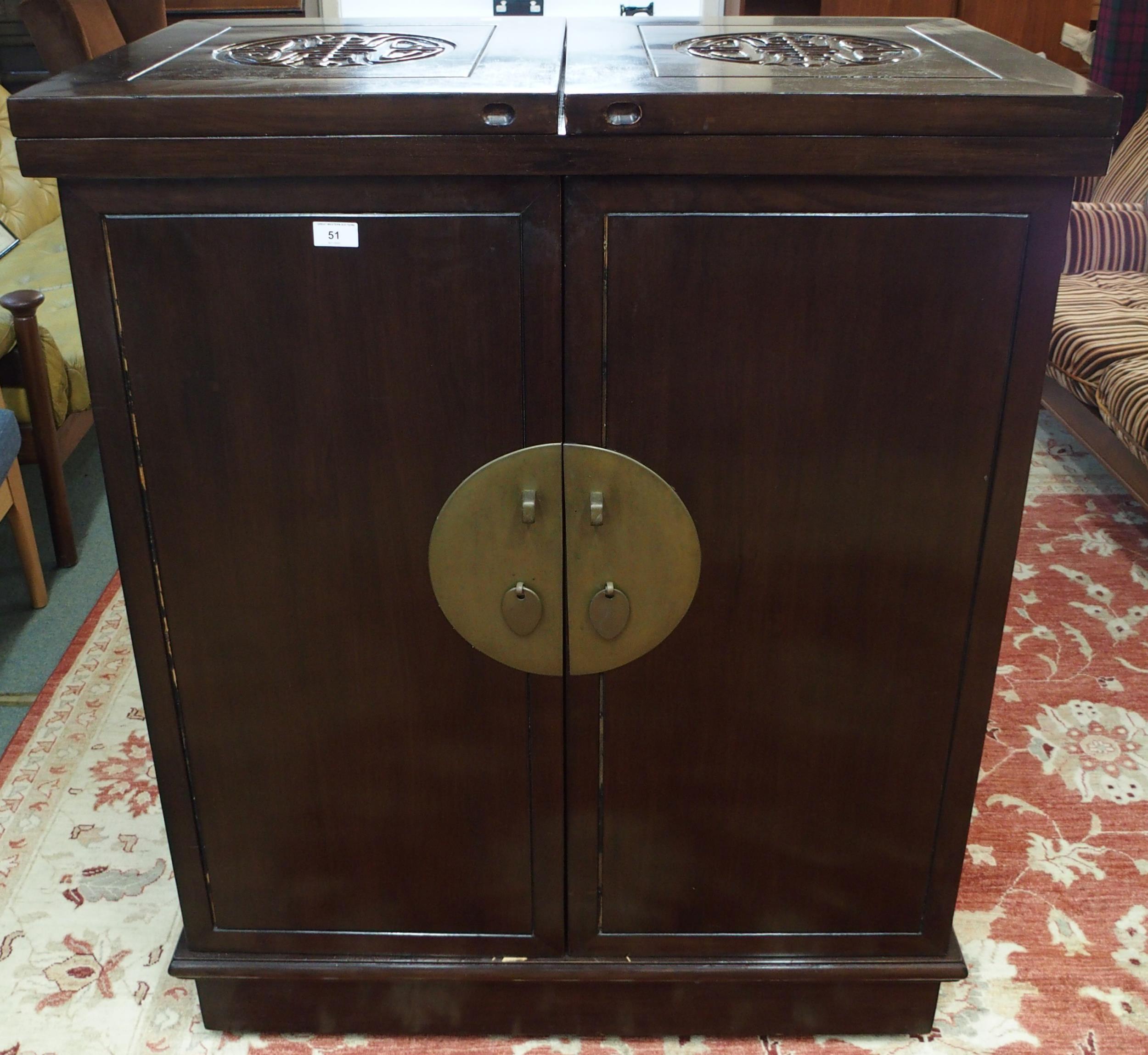 A 20th century Oriental hardwood drinks cabinet with pair of fold out top concealing marble insert