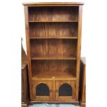 A contemporary hardwood open bookcase with four open shelves over pair of metal fretwork cabinet