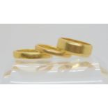 Three 18ct gold wedding rings, sizes (wide) J1/2, P and M1/2, weight together 12.2gms Condition
