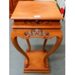 A contemporary square topped single drawer jardinière stand with carved fretwork friezes over