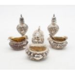 An Edwardian silver five piece condiment set, the bodies with repousse scrolling foliate