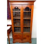 An early 20th century mahogany glazed bookcase with moulded cornice over pair of leaded glass