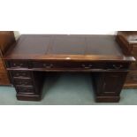 A contemporary hardwood pedestal desk with central long drawer flanked by four short drawers and