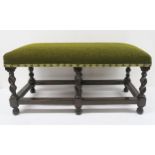 An early 20th century upholstered stool, the padded machine woven cover above six barley twist