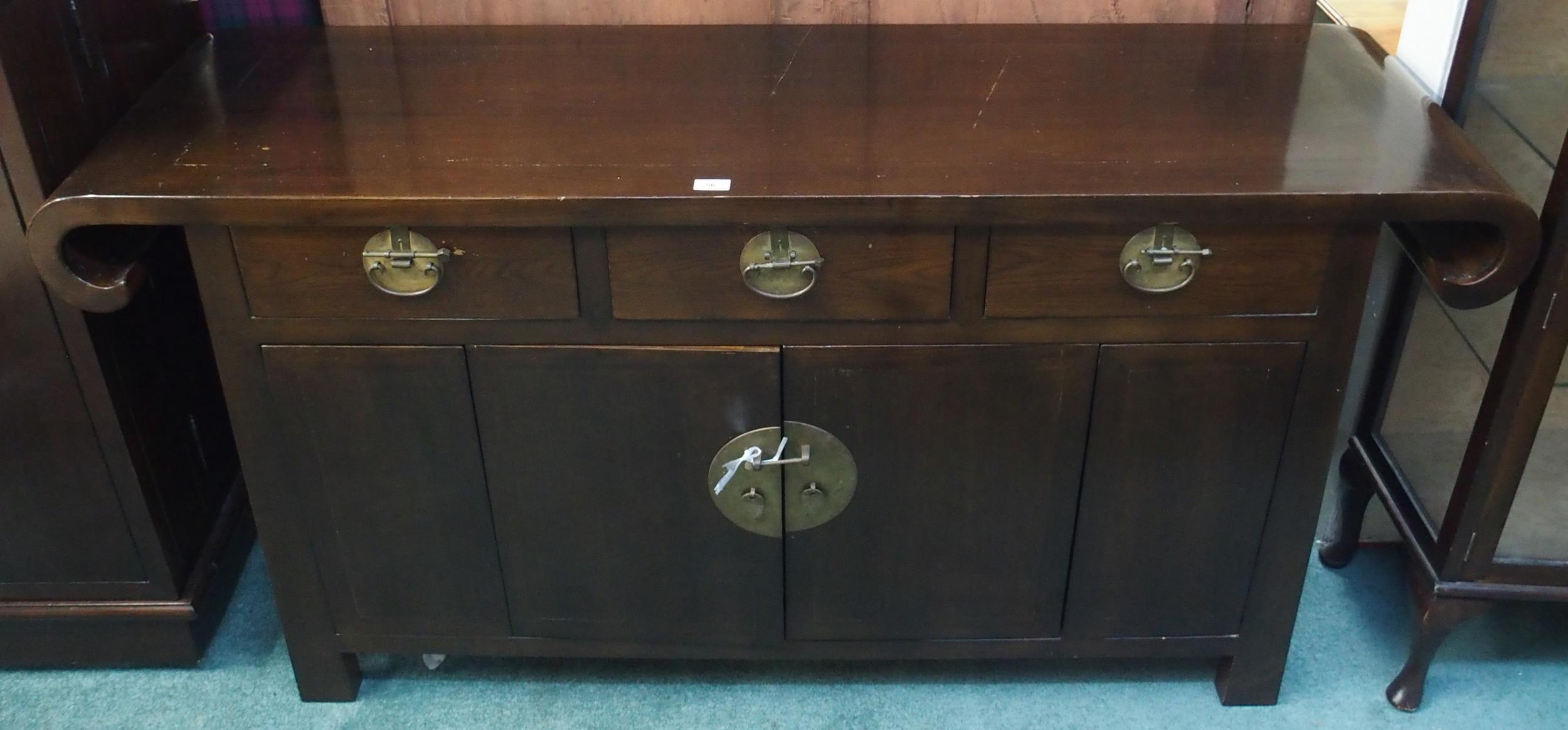 A 20th century Oriental hardwood sideboard with scroll end top over three drawers over pair of
