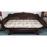 A contemporary Oriental hardwood day bed with carved back depicting phoenix and dragon over