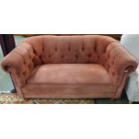 A 20th century two seater club settee with pink button back upholstery on turned feet, 75cm high x