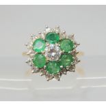 A DIAMOND AND EMERALD CLUSTER RING mounted throughout in 18ct gold, the central brilliant cut