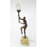 AN ART DECO LADY LAMP modelled standing on tip toes, with one knee and both arms raised, the arms