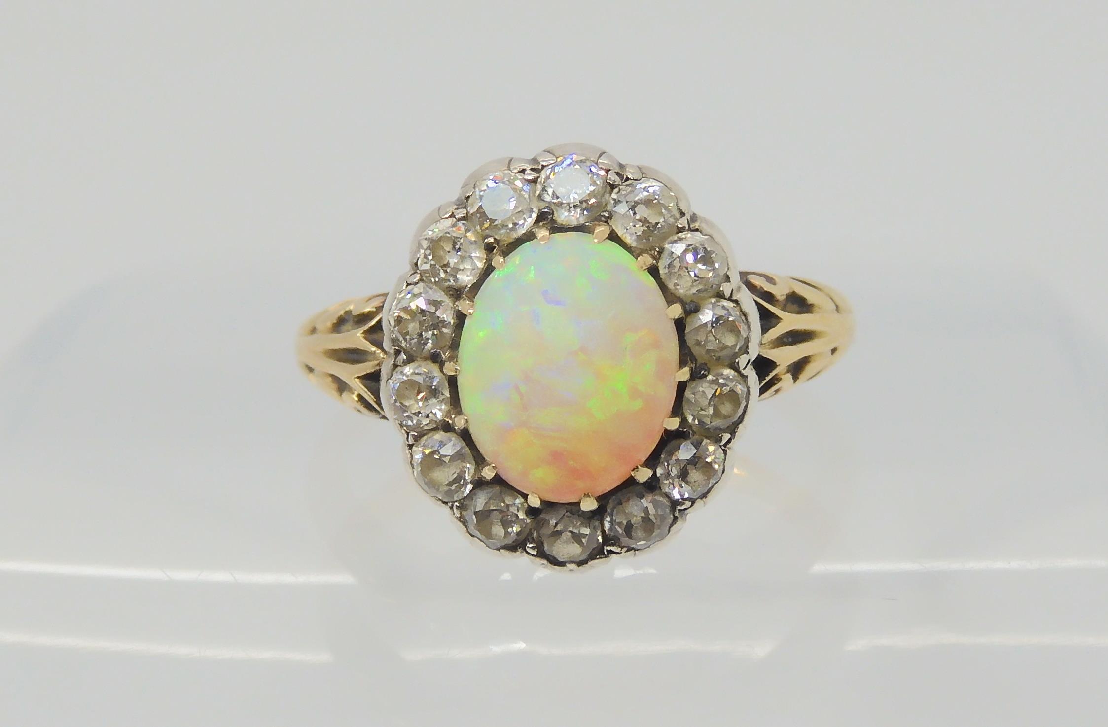 AN OPAL AND DIAMOND RING set with a high domed opal of approx 8.8mm x 7.1mm x 4.1mm, surrounded with