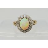 AN OPAL AND DIAMOND RING set with a high domed opal of approx 8.8mm x 7.1mm x 4.1mm, surrounded with