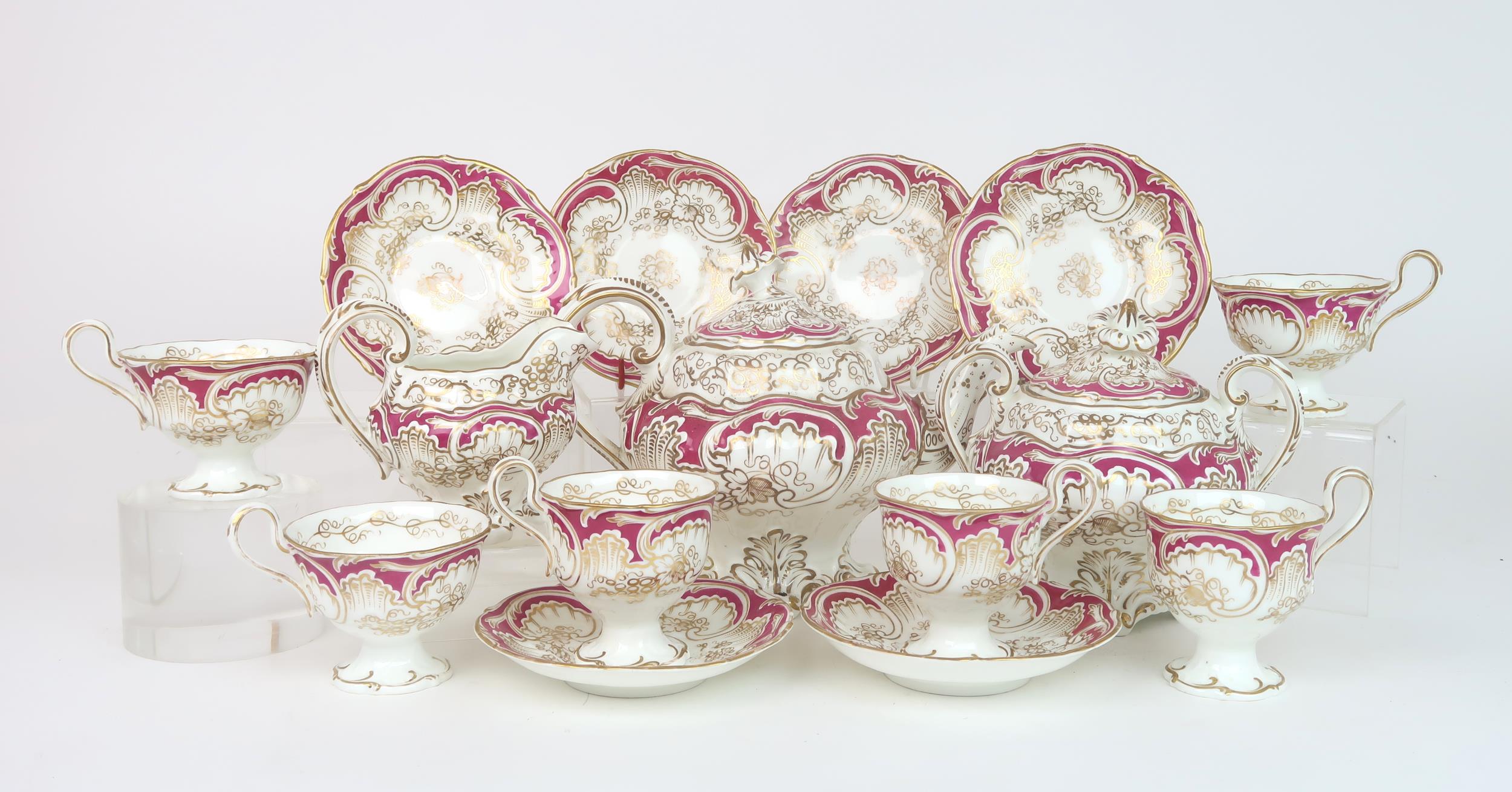 A ROCKINGHAM STYLE TEASET of moulded rococo design, the white ground with gilt vine and grape