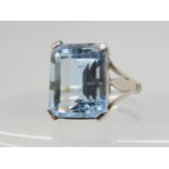 AN AQUAMARINE RING the mount hand made in white metal with fleur de lis shoulders, finger size M,