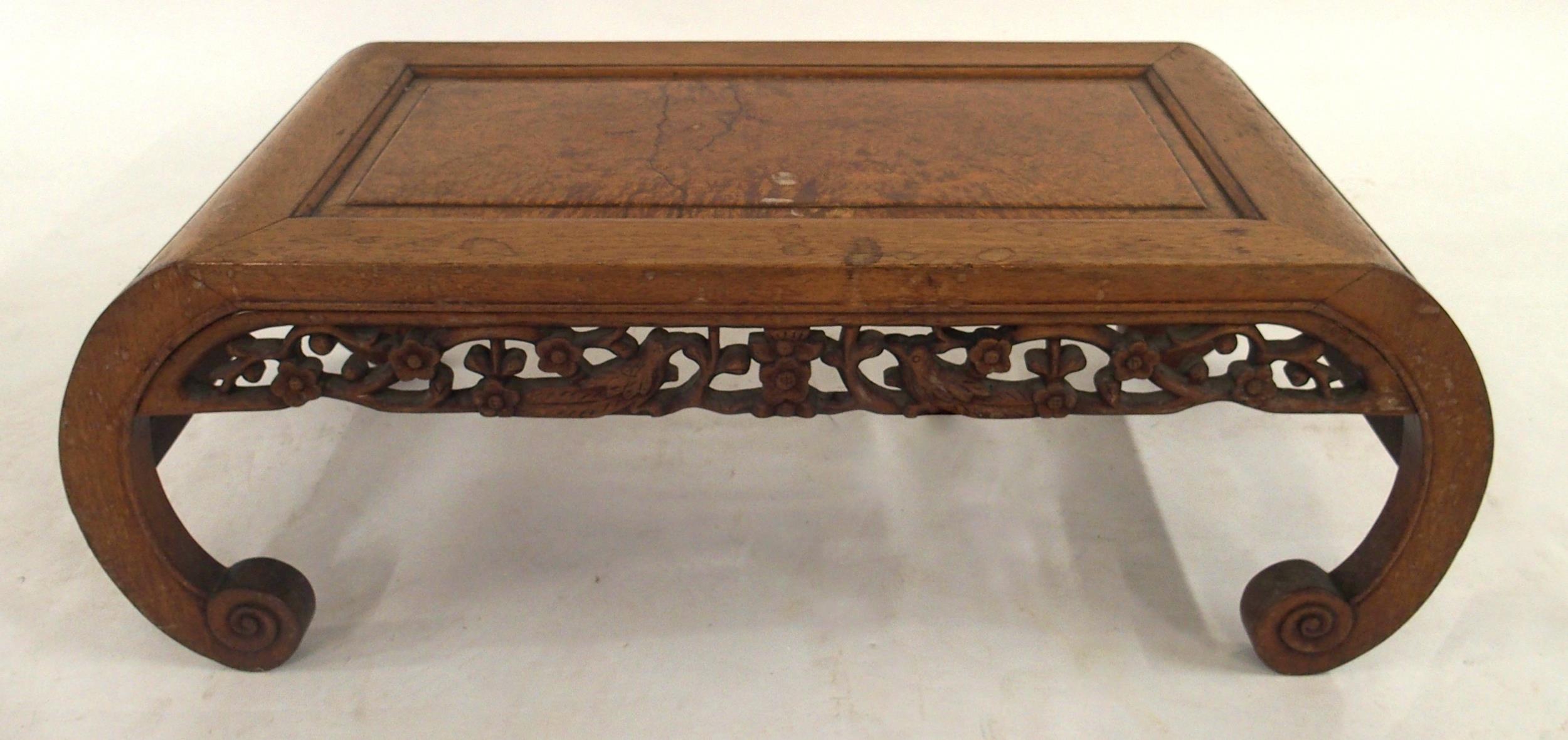 A 20TH CENTURY CHINESE HARDWOOD LOW TABLE with central birds eye maple panel, carved floral fretwork