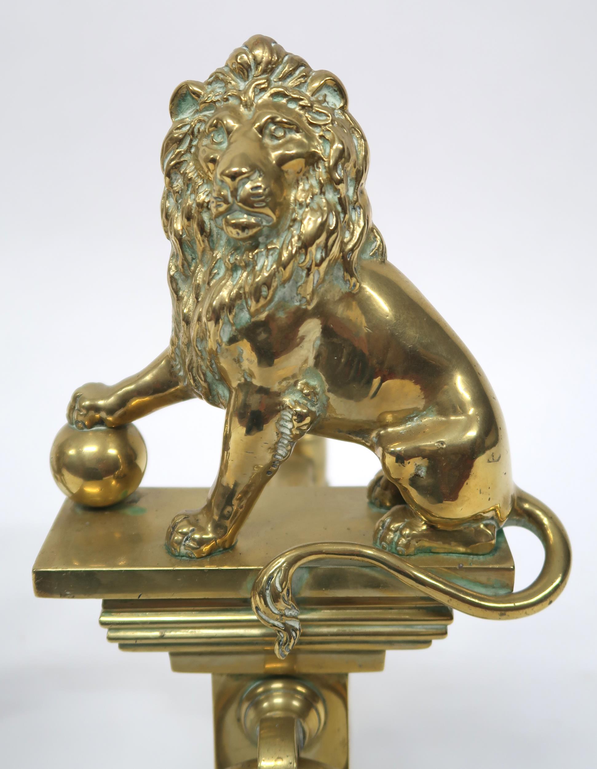 A PAIR OF EARLY 20TH CENTURY CAST BRASS FIRE DOGS mounted with figural lions, 46cm high x 23cm - Image 3 of 7