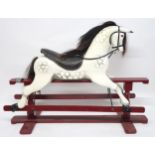 A 20TH CENTURY DAPPLE GREY PAINTED ROCKING HORSE with black leather saddle and reigns, horse hair