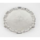 A GEORGE V SILVER SALVER of plain form, with a chippendale pie crust border, engraved to the