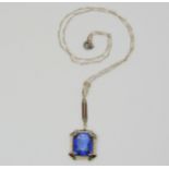 A 14K ART DECO PENDANT set with a large faux sapphire, with enamelled details, and seed pearls.