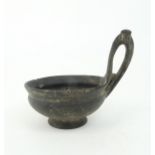 AN ESTRUSCAN BUCCHERO KYATHOS of plain, slightly swollen form with a single looped handle, set on