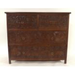 A 20TH CENTURY AFRICAN HARDWOOD TWO OVER TWO CHEST OF DRAWERS  with extensively carved drawer