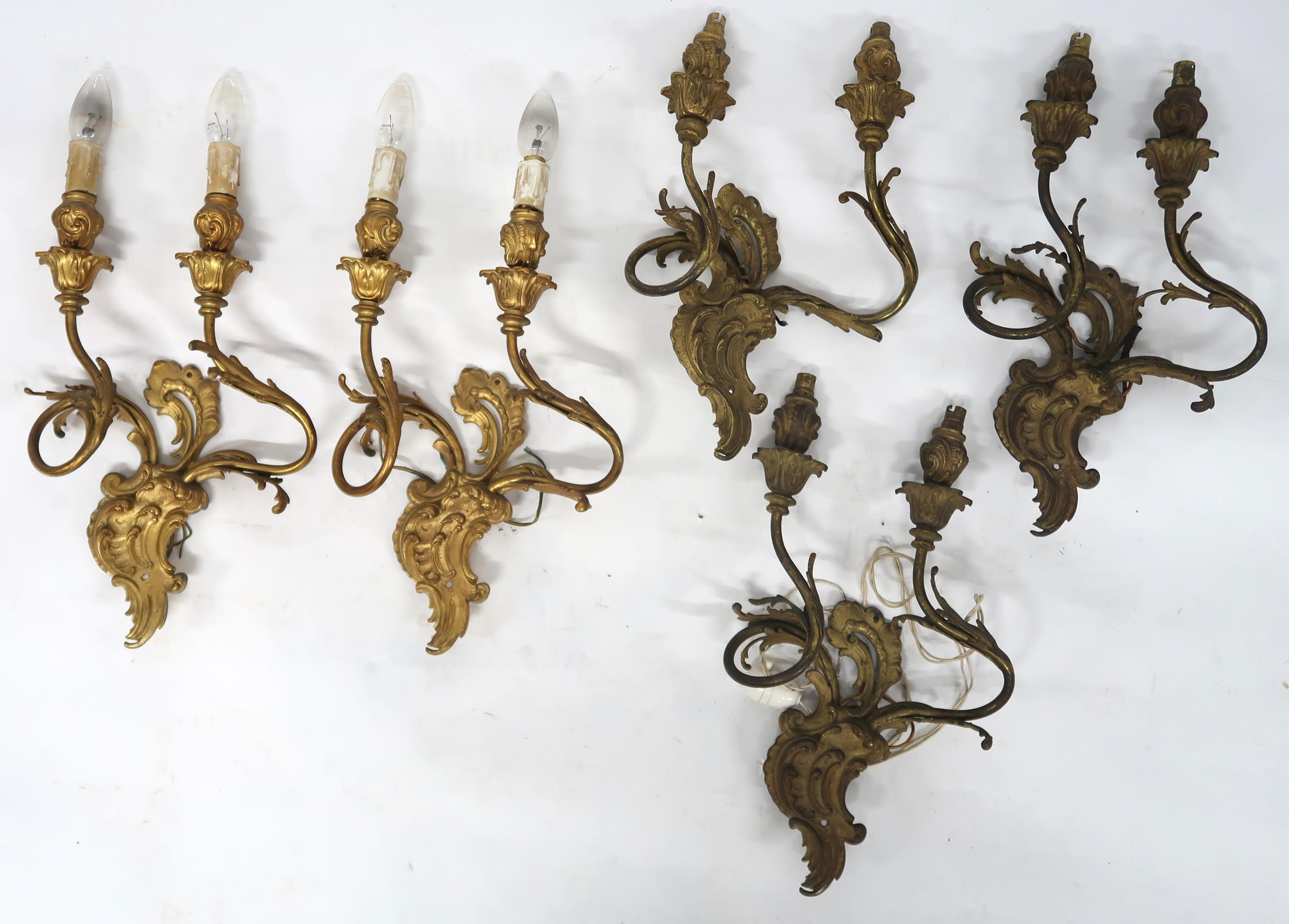 A LOT OF FIVE ROCOCO STYLE GILT METAL ORMOLU TWO BRANCH WALL SCONCES with scroll and acanthus back