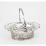 A GEORGE II SILVER SWING HANDLED CAKE BASKET of shaped oval form, the border with threaded shellwork